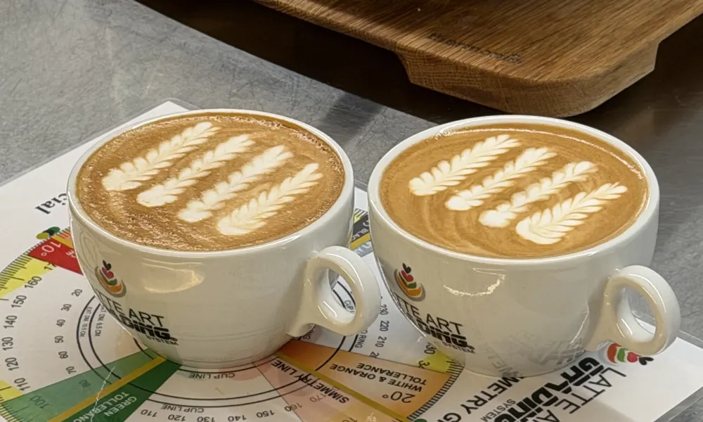Dos tazas de café con latte art sobre una plantilla de Latte Art Grading